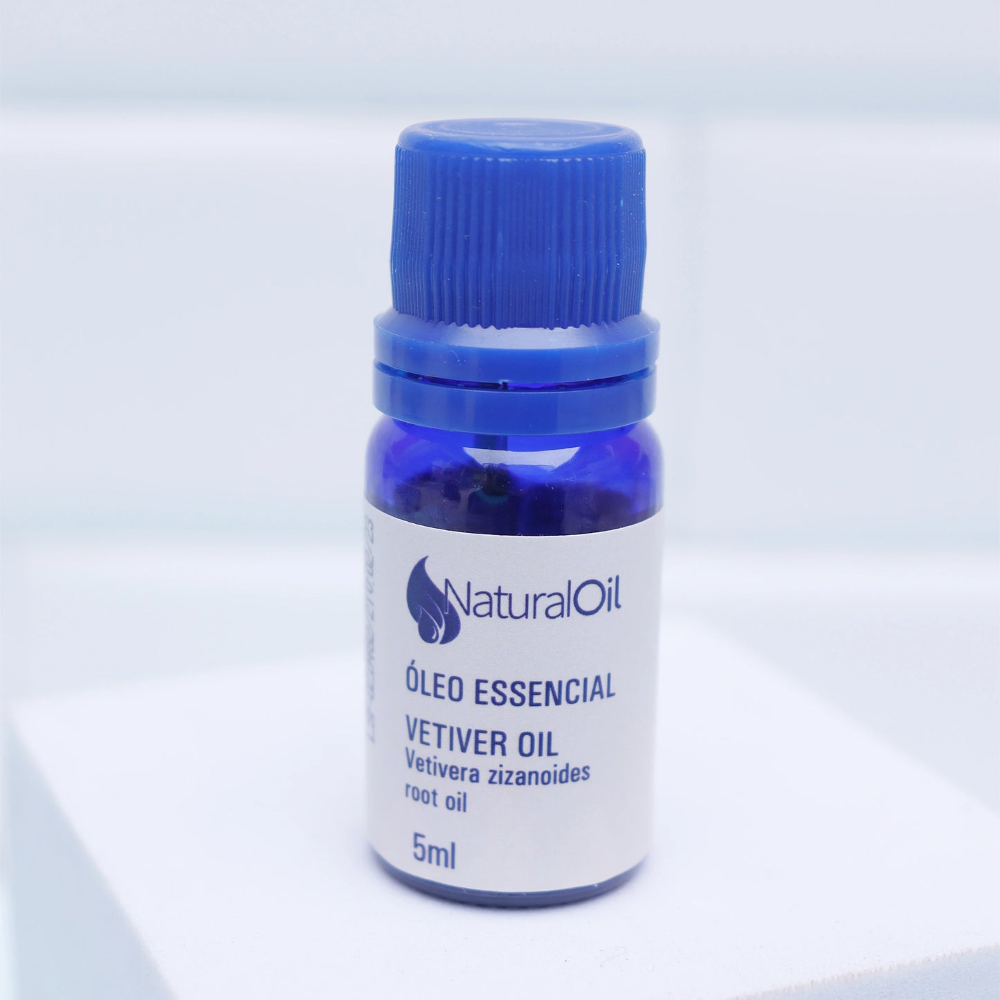 Frasco azul de óleo essencial vetiver de 5ml para aromaterapia e bem-estar.